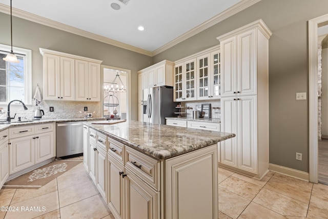 kitchen with sink, stainless steel appliances, tasteful backsplash, decorative light fixtures, and a kitchen island