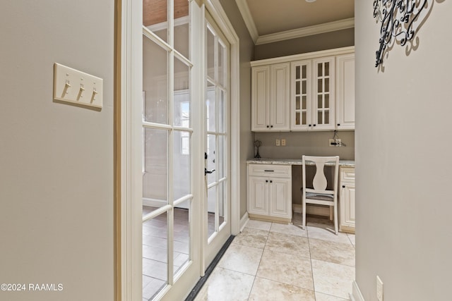 interior space featuring light stone countertops, built in desk, crown molding, and light tile patterned floors