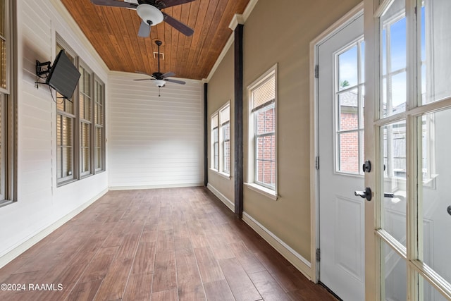 unfurnished sunroom with ceiling fan, plenty of natural light, and wooden ceiling