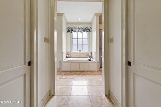 bathroom featuring tile patterned floors, a washtub, and ornamental molding