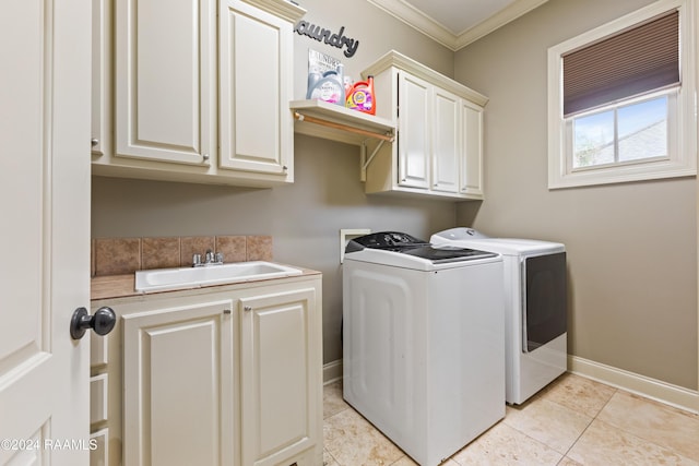 laundry area with cabinets, sink, washing machine and dryer, ornamental molding, and light tile patterned floors