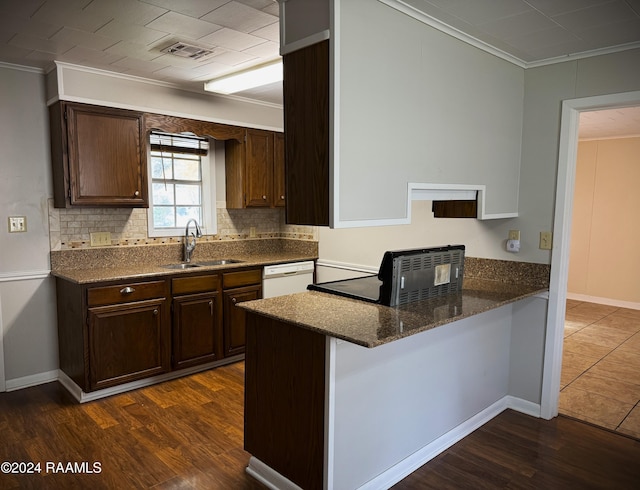 kitchen with dark wood-type flooring, white dishwasher, sink, crown molding, and kitchen peninsula