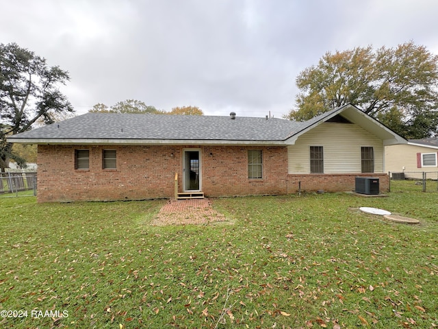 rear view of property with a lawn and central AC unit