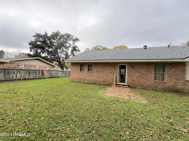 rear view of property featuring a yard