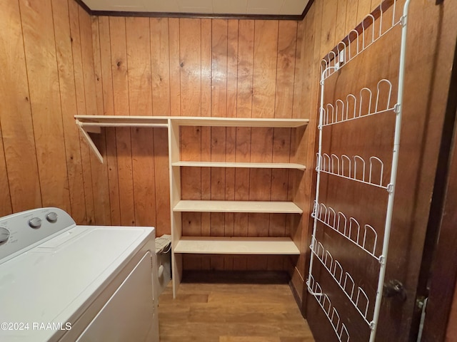 washroom with washer / dryer, wood-type flooring, and wooden walls