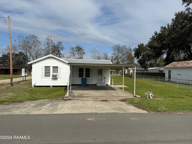 view of front of house with a front yard, a carport, and cooling unit