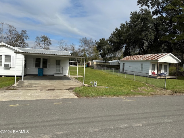 view of front of property featuring cooling unit, a front lawn, and a carport