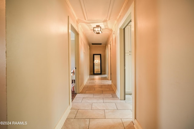 corridor with light tile patterned floors and crown molding