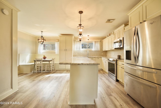 kitchen featuring light stone countertops, stainless steel appliances, light hardwood / wood-style flooring, a center island, and hanging light fixtures