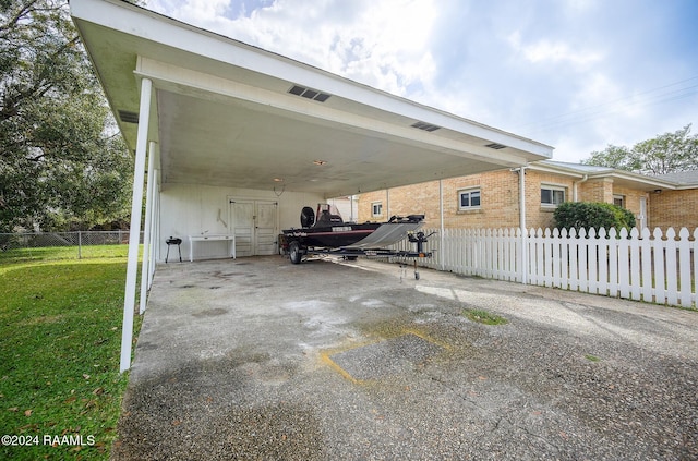 view of side of property with a carport and a lawn