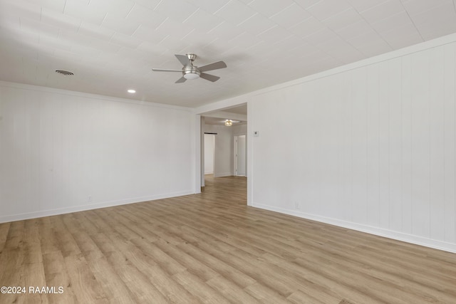 spare room with ornamental molding, ceiling fan, and light wood-type flooring