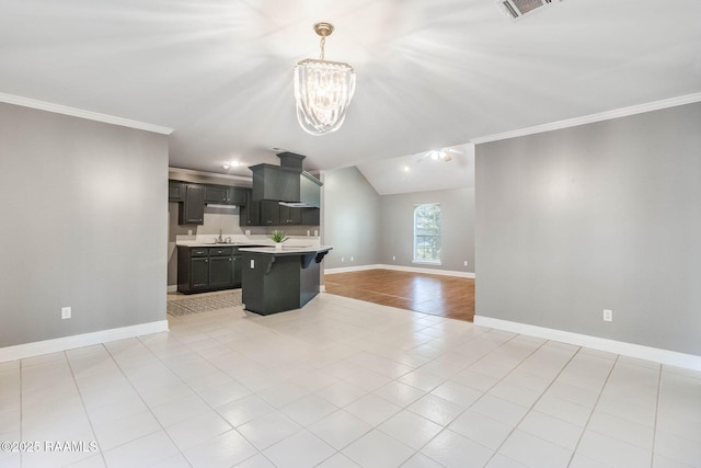 kitchen featuring open floor plan, a kitchen island, light countertops, ventilation hood, and a notable chandelier