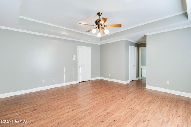 spare room featuring crown molding, light hardwood / wood-style flooring, a raised ceiling, and ceiling fan