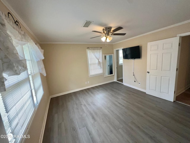 unfurnished bedroom with dark wood-style floors, crown molding, and visible vents