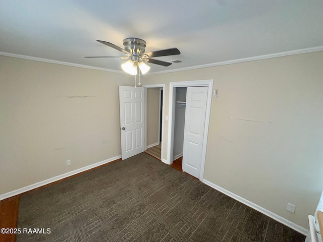 unfurnished bedroom with a closet, crown molding, baseboards, and visible vents
