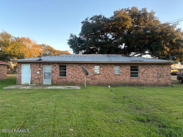 rear view of house with a patio area and a lawn