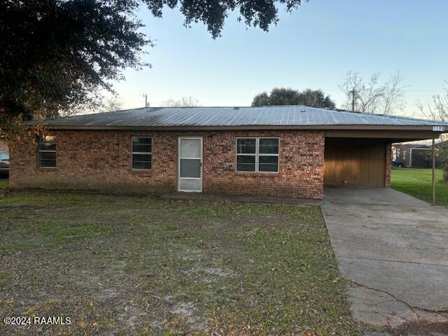 single story home with a carport and a front lawn