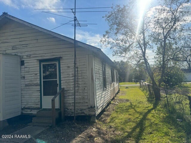 view of side of home with a yard