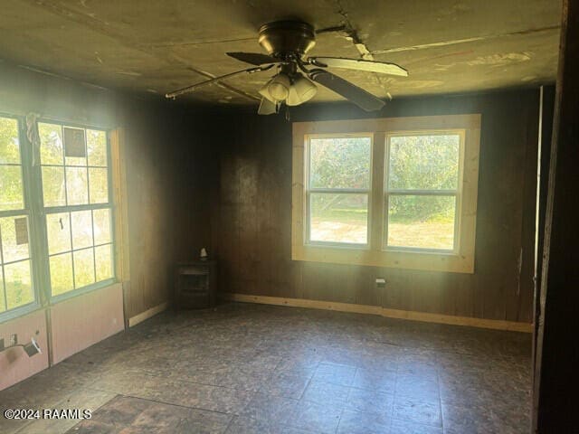 empty room featuring a wealth of natural light and ceiling fan