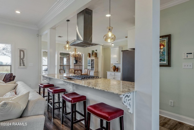 kitchen with white cabinetry, island range hood, stainless steel appliances, and decorative light fixtures