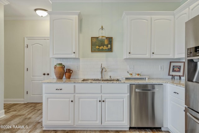 kitchen with white cabinetry, appliances with stainless steel finishes, sink, and light stone counters