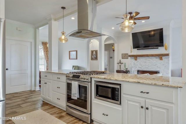 kitchen with white cabinetry, hanging light fixtures, island range hood, and appliances with stainless steel finishes