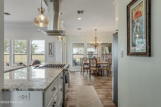 kitchen featuring white cabinetry, island range hood, stainless steel appliances, and crown molding