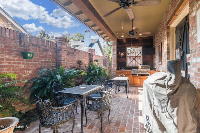 view of patio featuring area for grilling, ceiling fan, and exterior kitchen