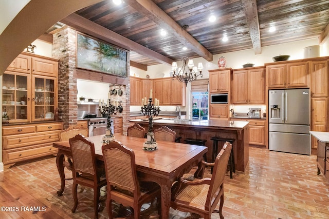 dining room featuring beam ceiling, a towering ceiling, wood ceiling, and a notable chandelier