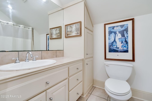 bathroom featuring tile patterned floors, vanity, toilet, and vaulted ceiling