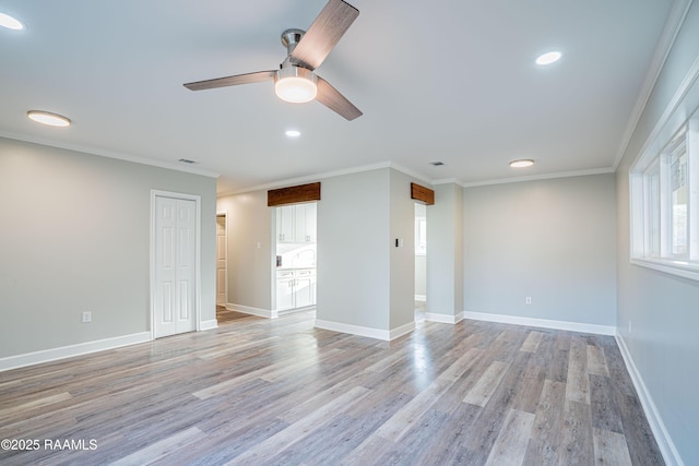 empty room with crown molding, ceiling fan, and light hardwood / wood-style flooring