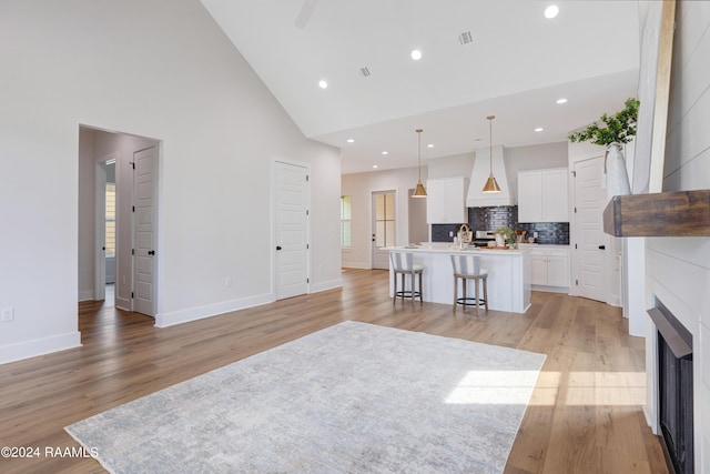 living room with high vaulted ceiling and light hardwood / wood-style floors