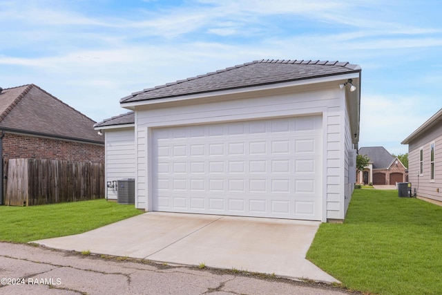 garage featuring a lawn and cooling unit