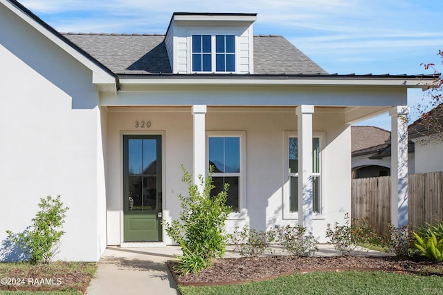 320 Dunvegan Ct, Lafayette, LA 70503 - view of exterior entry featuring a shingled roof, stucco siding, and a porch