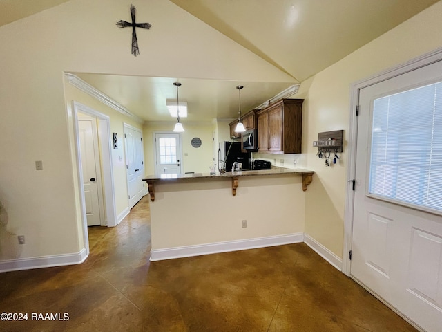 kitchen featuring a breakfast bar, hanging light fixtures, kitchen peninsula, lofted ceiling, and black refrigerator