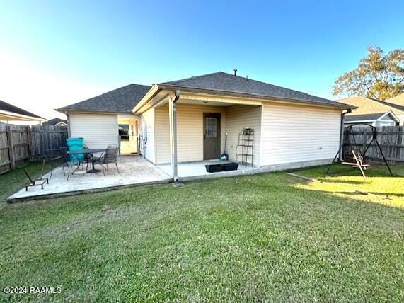 rear view of house with a lawn and a patio