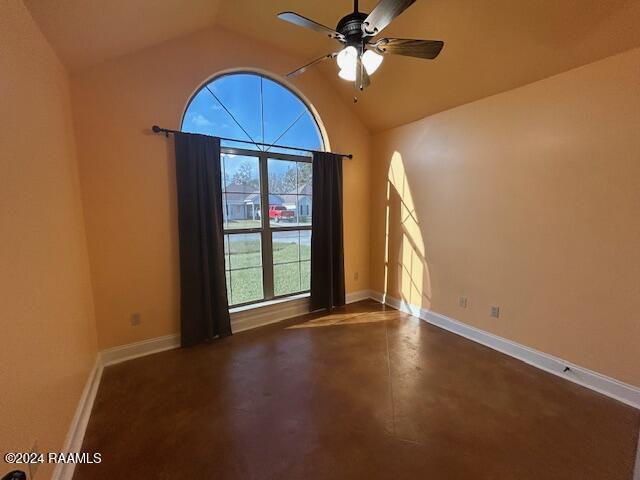 empty room with ceiling fan and vaulted ceiling