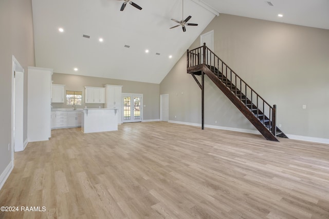 unfurnished living room with high vaulted ceiling, sink, ceiling fan, beam ceiling, and light hardwood / wood-style floors