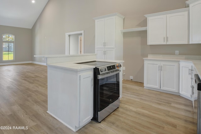 kitchen with white cabinetry, stainless steel range with electric cooktop, and high vaulted ceiling