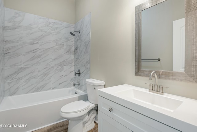 full bathroom featuring hardwood / wood-style flooring, vanity, tiled shower / bath combo, and toilet