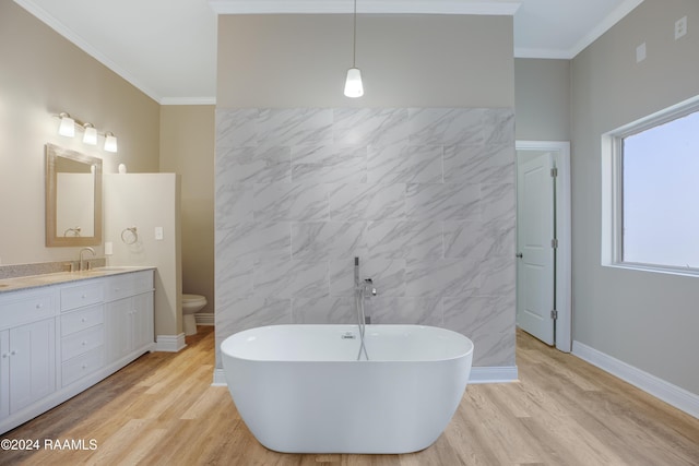 bathroom featuring a bath, ornamental molding, toilet, vanity, and hardwood / wood-style flooring