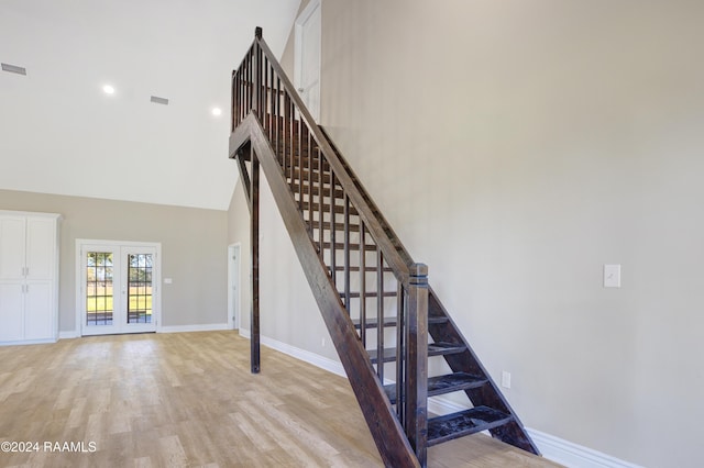 stairs with a high ceiling and hardwood / wood-style flooring