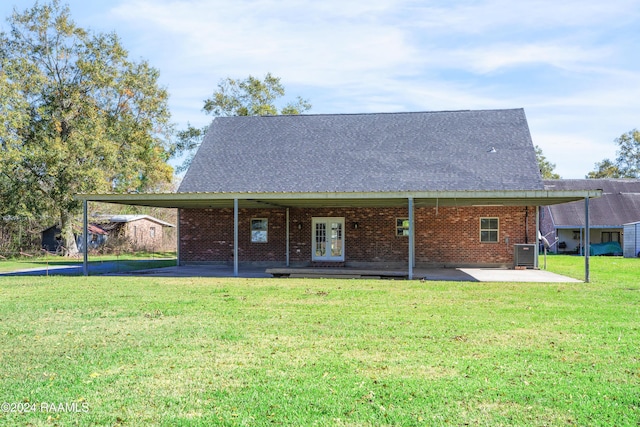 rear view of house with a yard, a patio, and central AC unit