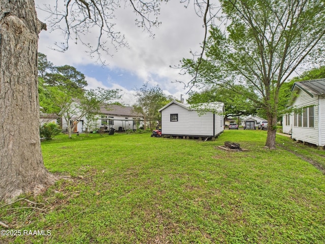 view of yard with an outdoor fire pit and an outdoor structure
