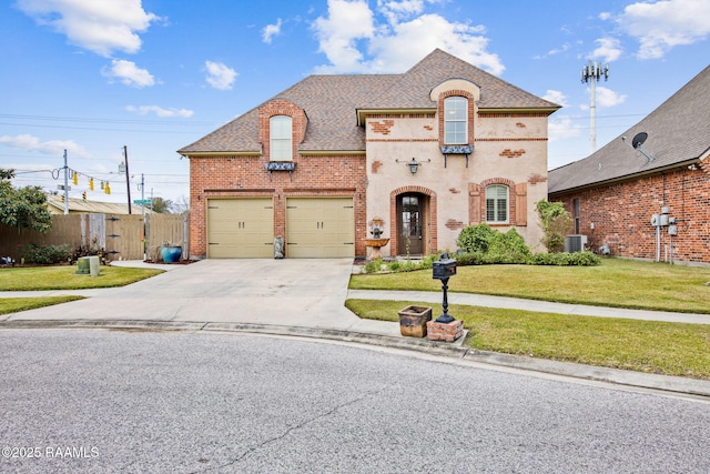 french country inspired facade featuring fence, central AC unit, driveway, a front lawn, and brick siding