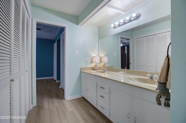 bathroom featuring a textured ceiling, hardwood / wood-style flooring, and vanity