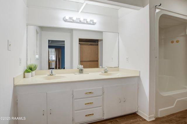 bathroom with walk in shower, vanity, and hardwood / wood-style floors