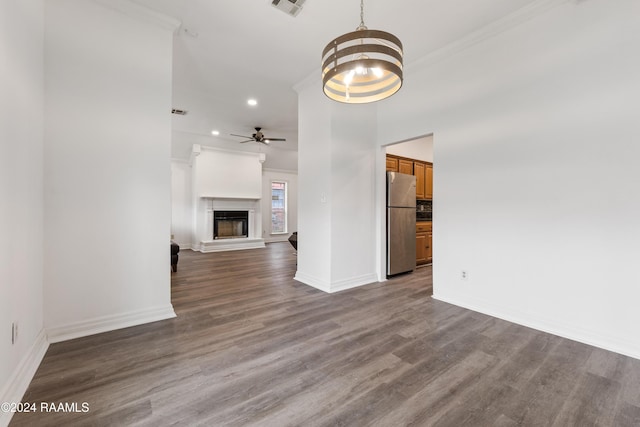 unfurnished living room with hardwood / wood-style floors, ceiling fan with notable chandelier, and crown molding