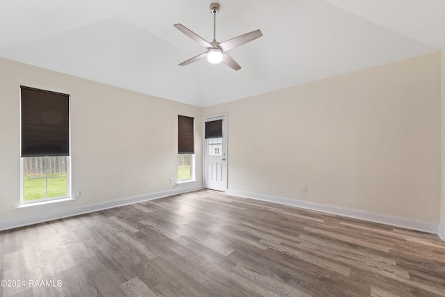 empty room with hardwood / wood-style floors, ceiling fan, a healthy amount of sunlight, and lofted ceiling