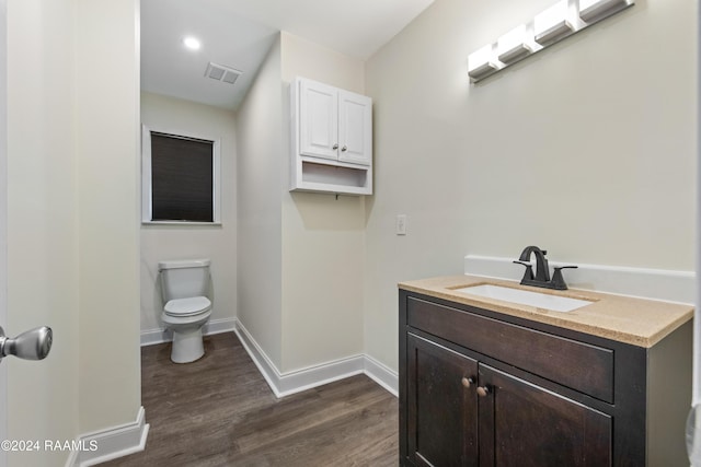 bathroom with hardwood / wood-style flooring, vanity, and toilet